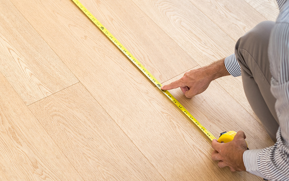 A person measuring part of the floor