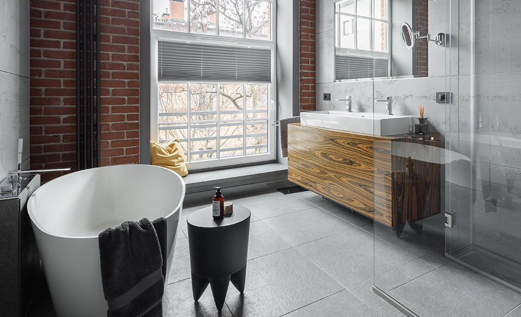 An industrial primary bathroom featuring concrete gray floors. An industrial primary bathroom featuring concrete gray floors.