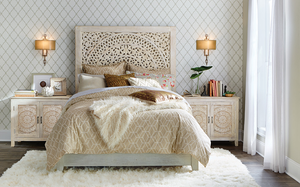 Carved headboard and matching nightstands used in a neutral bedroom.