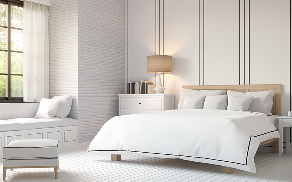 Master bedroom with white bedding and other white decor.
