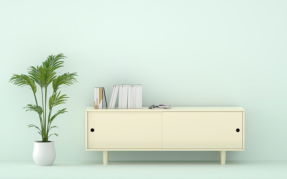 A console table in a room with mint green walls.