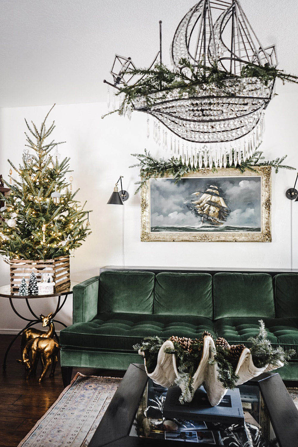 A nautical themed room with a green sofa and holiday greenery.