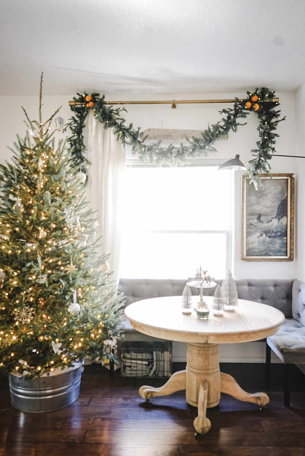 A room with a decorated Christmas tree sitting in metal tub.