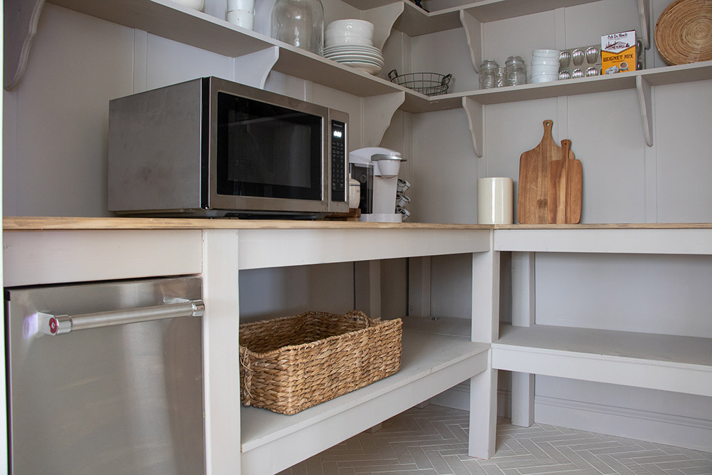 A stainless steel KitchenAid ice machine and microwave inside a pantry. A stainless steel KitchenAid ice machine and microwave inside a pantry.
