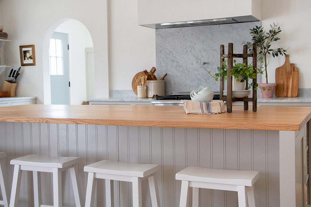 A large kitchen island with white barstools.