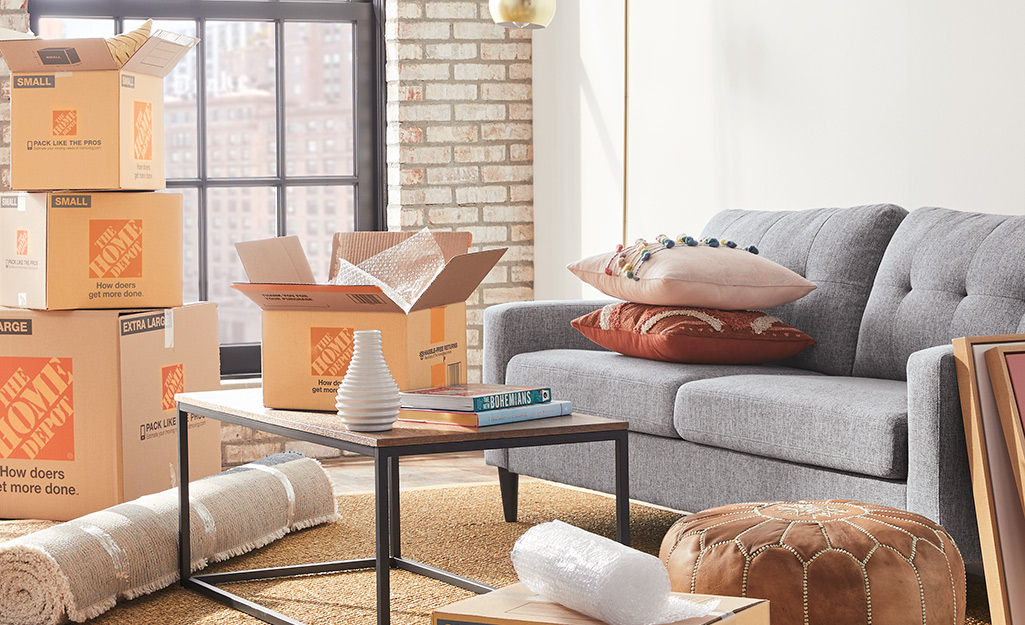 A living room filled with different Home Depot moving boxes.