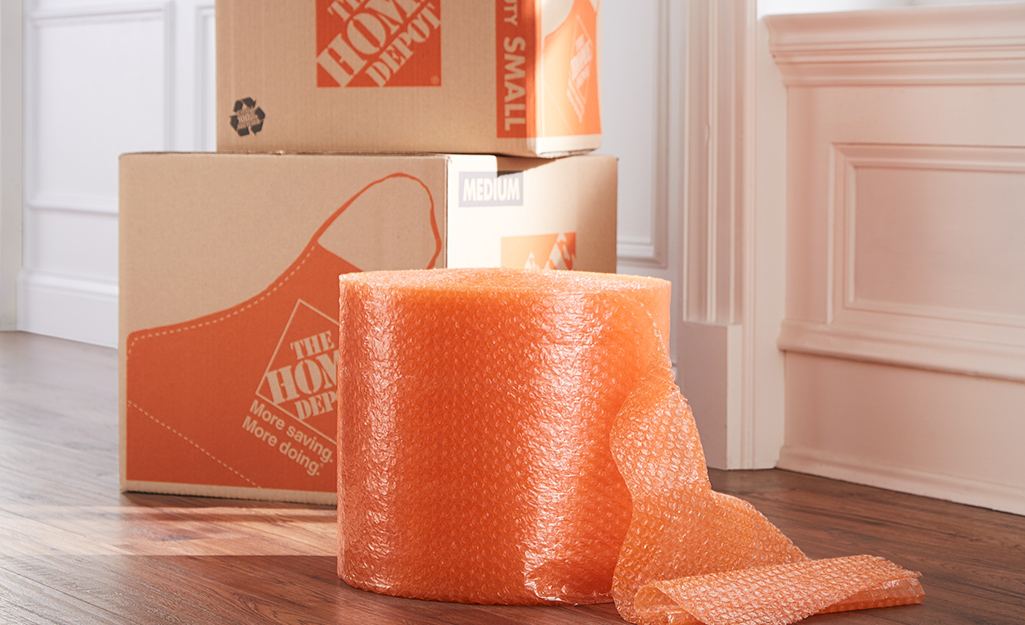 Orange bubble wrap and moving boxes sitting next to a door. Orange bubble wrap and moving boxes sitting next to a door.