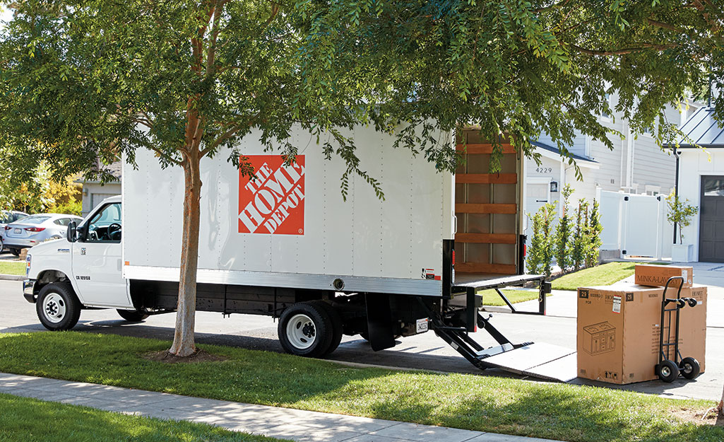 A Home Depot moving truck parked on the street in a neighborhood.