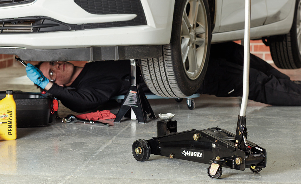 Mechanic using a dolly under a car.