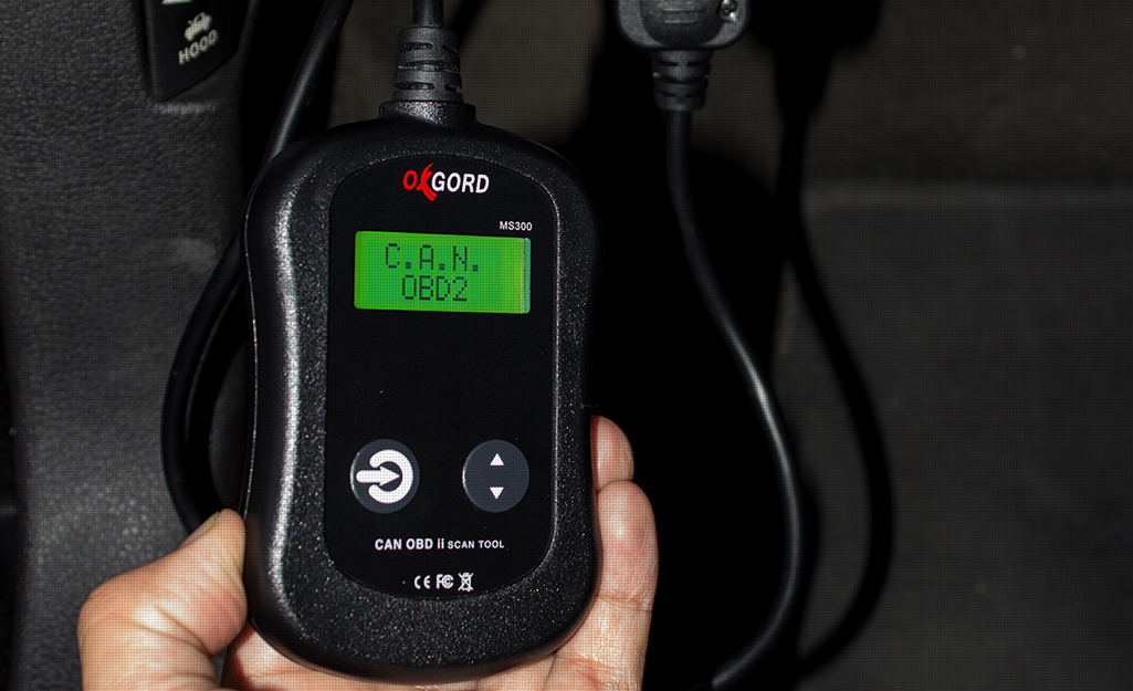 A person holding an OBD2 scanner