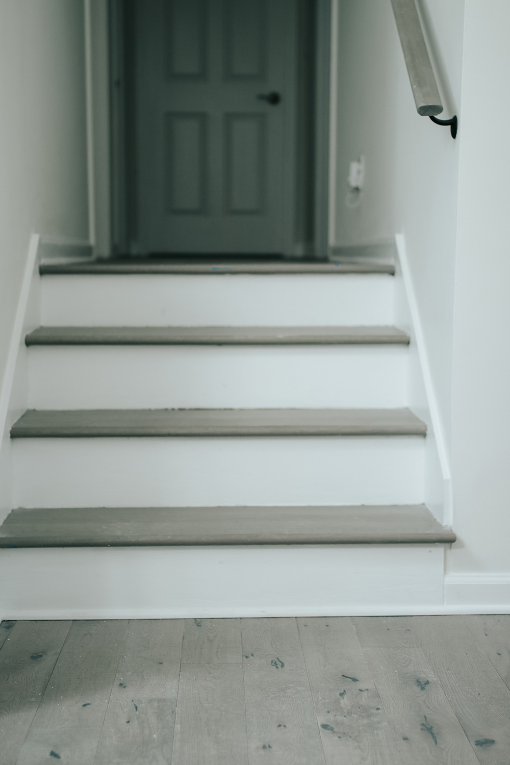 Matching hardwood floors meet at the bottom of a stairway. Matching hardwood floors meet at the bottom of a stairway.