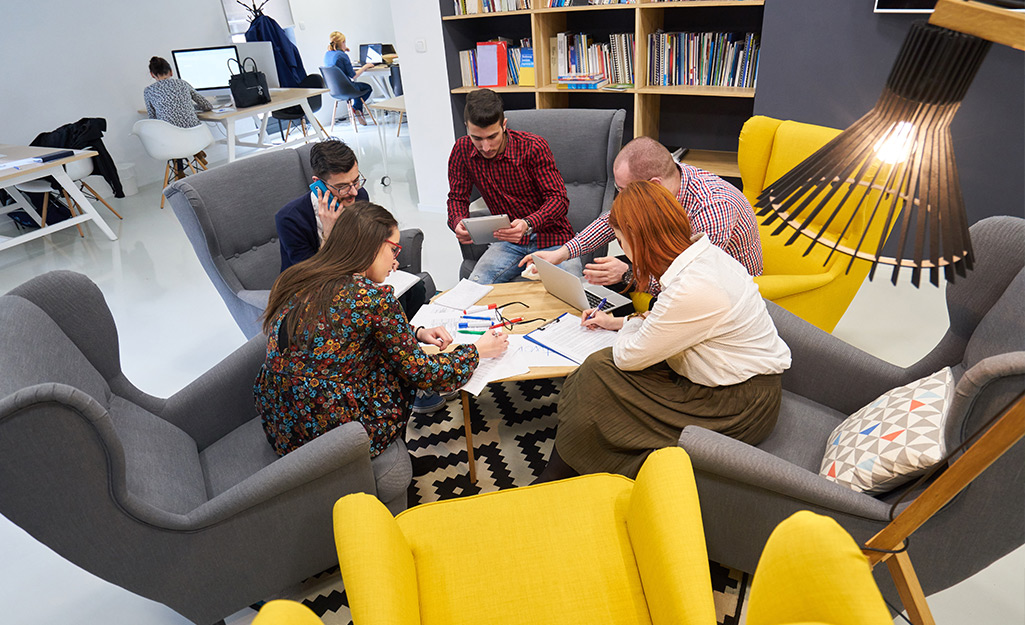 People meeting and sitting in overstuffed gray and yellow upholstered chairs. People meeting and sitting in overstuffed gray and yellow upholstered chairs.