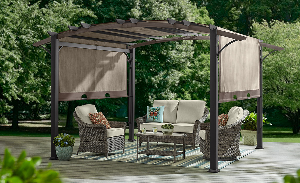 A pergola with drop-down panels in a garden setting