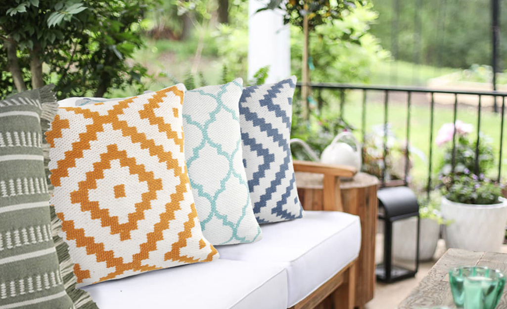 Several colorful outdoor pillows in an outdoor living space.