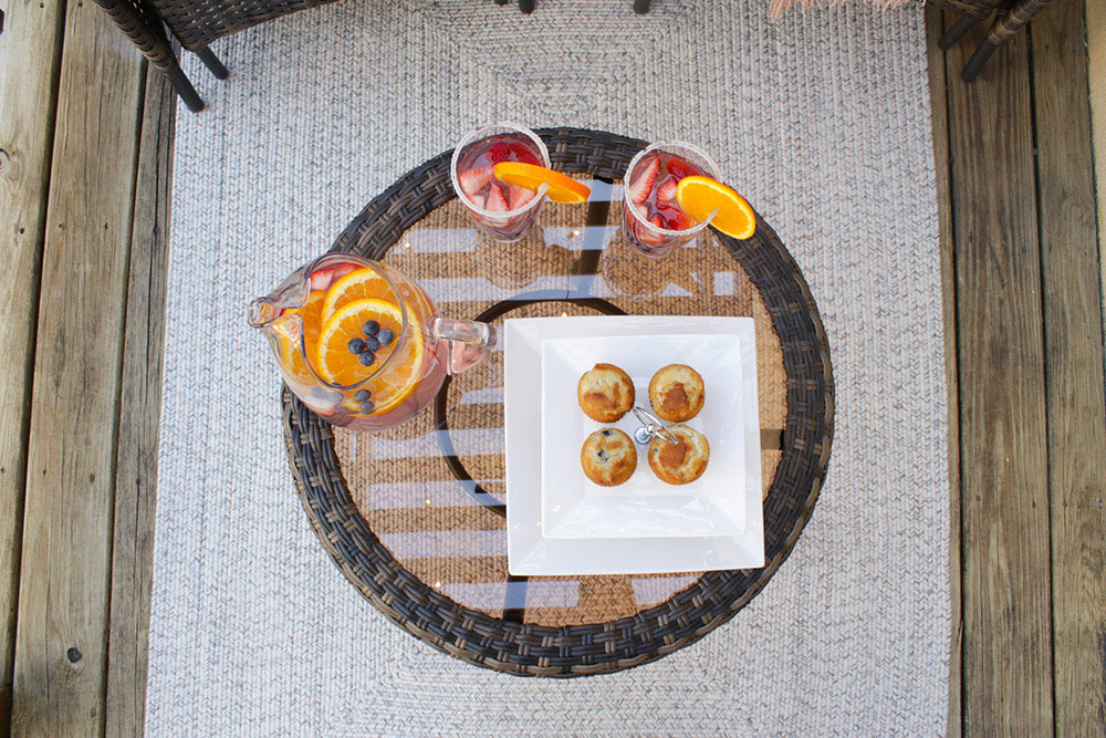 A small patio table decorated with drinks and snacks.