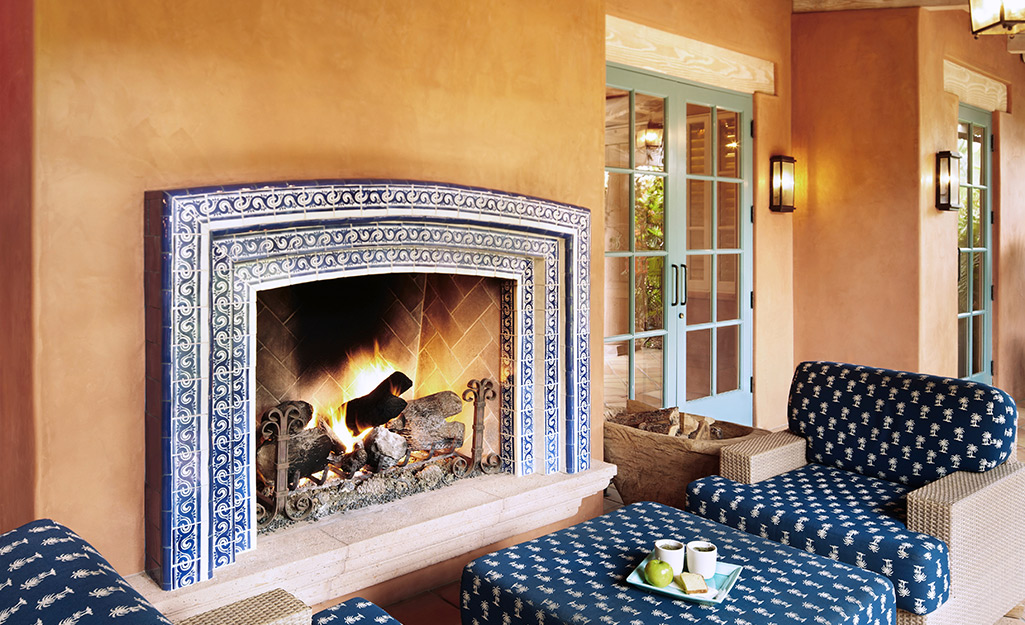 An outdoor fireplace tiled in blue and white tile.
