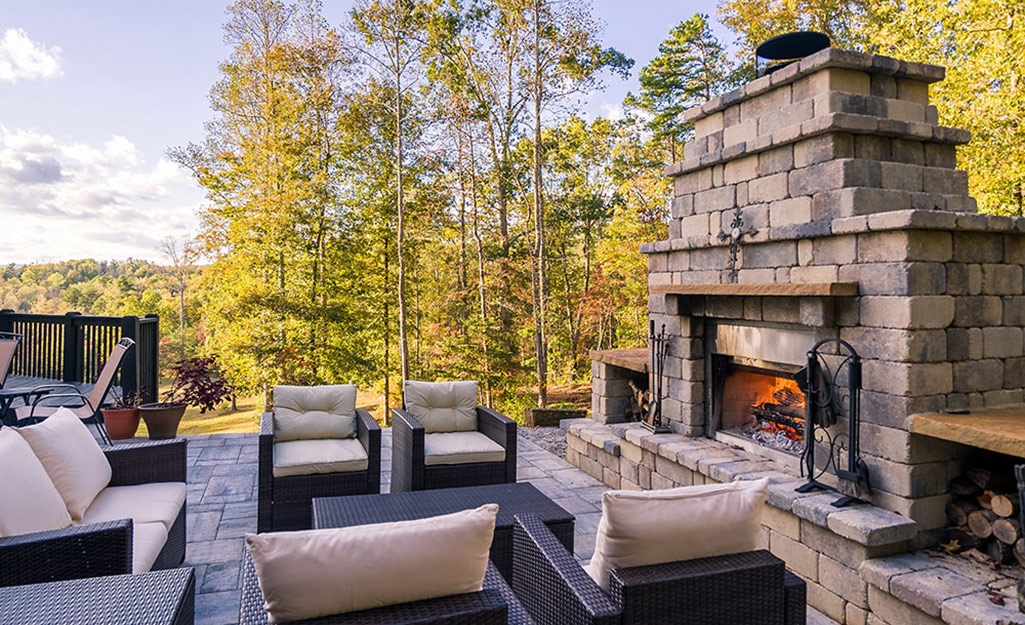 A stone outdoor fireplace surrounded by plenty of comfortable seating.