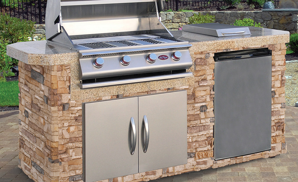 An outdoor kitchen with a mini refrigerator.