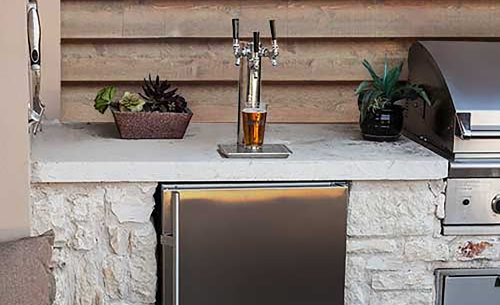 An outdoor kitchen with a kegerator.