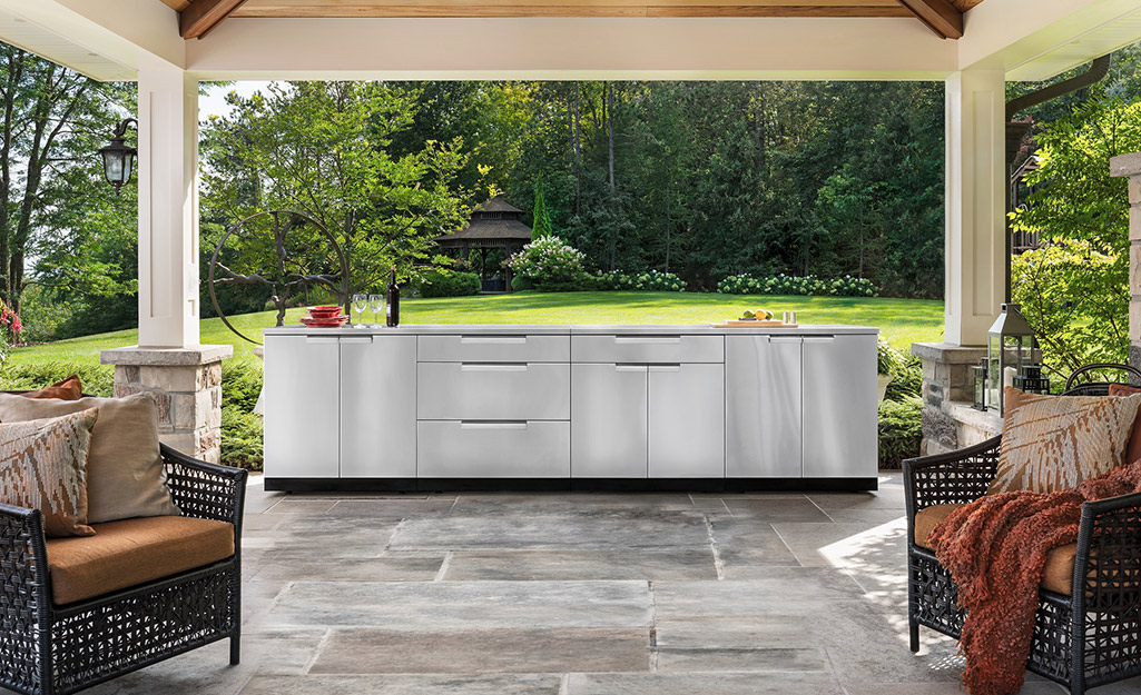 A stainless steel outdoor kitchen with a built-in refrigerator.