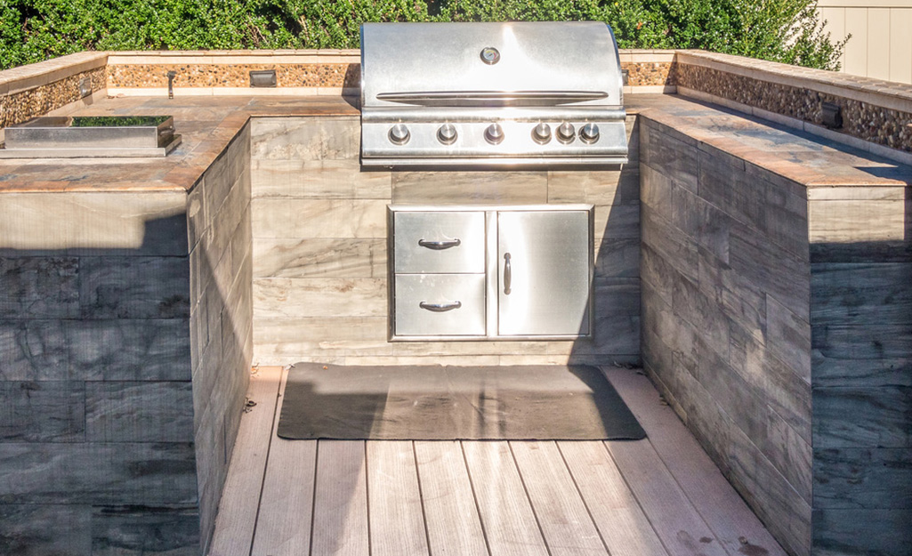 A U-shaped outdoor kitchen with a built-in grill.