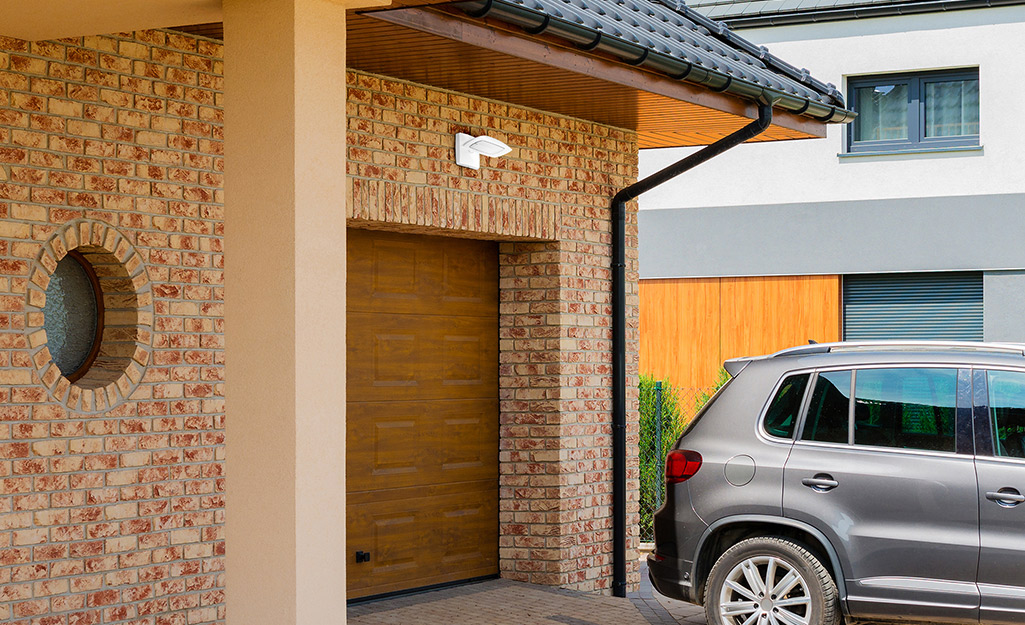 Garage door being illuminated by outdoor security light.