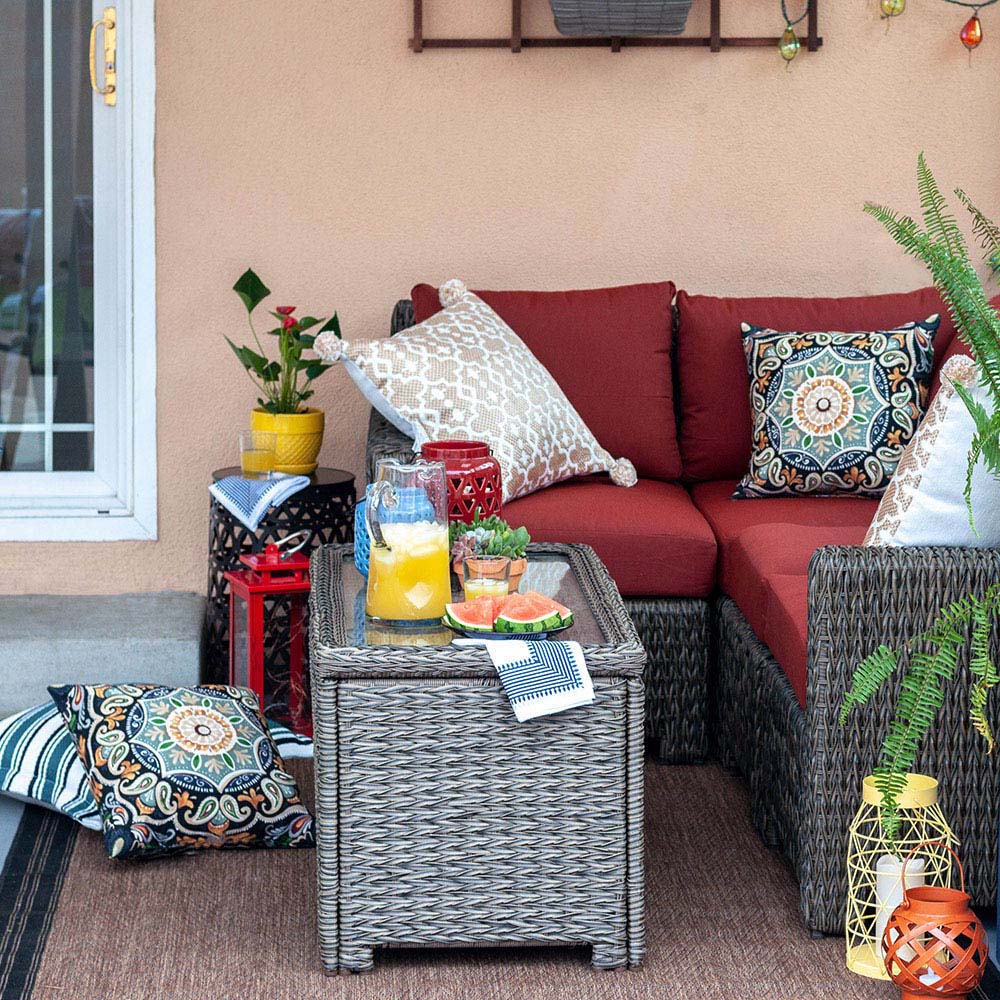 A small patio with an outdoor sectional and pillows.