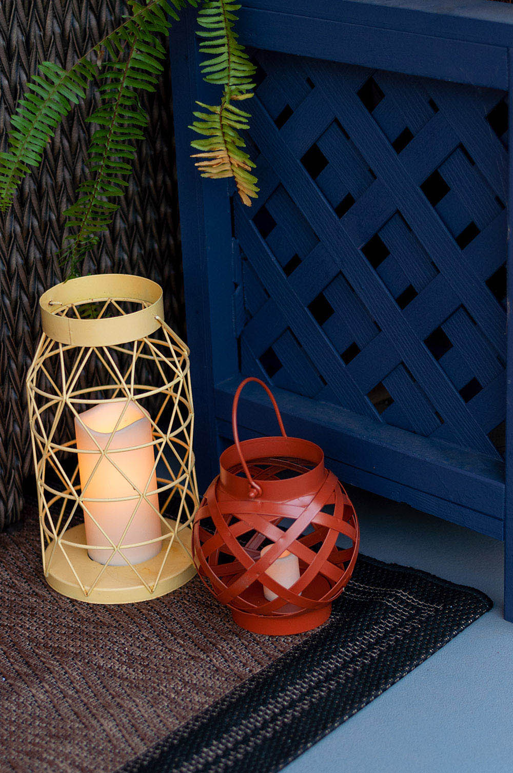 A tall yellow lantern and short red lantern filled with flameless LED candles.