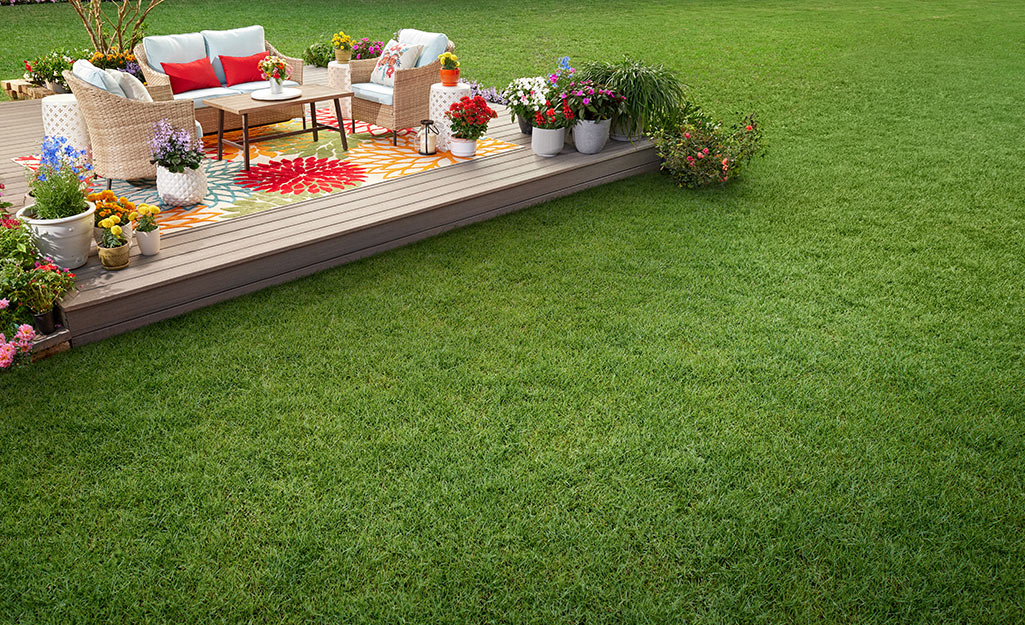 A green lawn featuring a fully furnished deck.