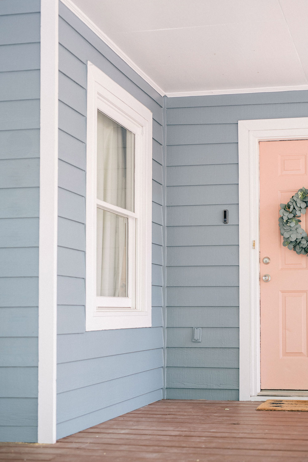 A pink front door with a green wreath.