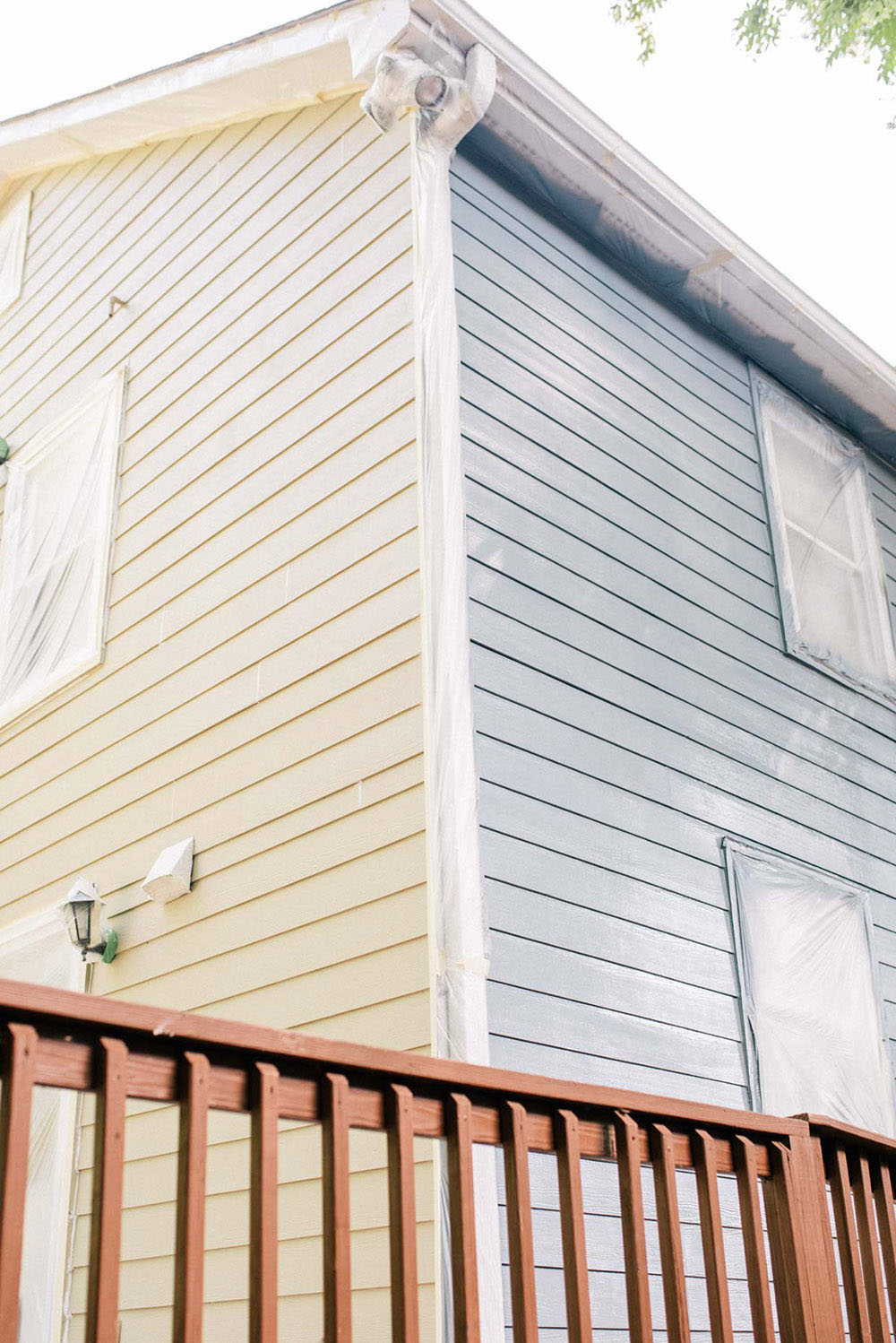 A home's exterior painted beige on one side and blue on the other.