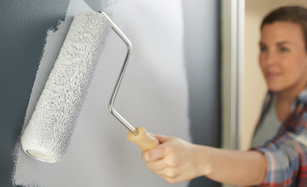 Woman priming a wall.