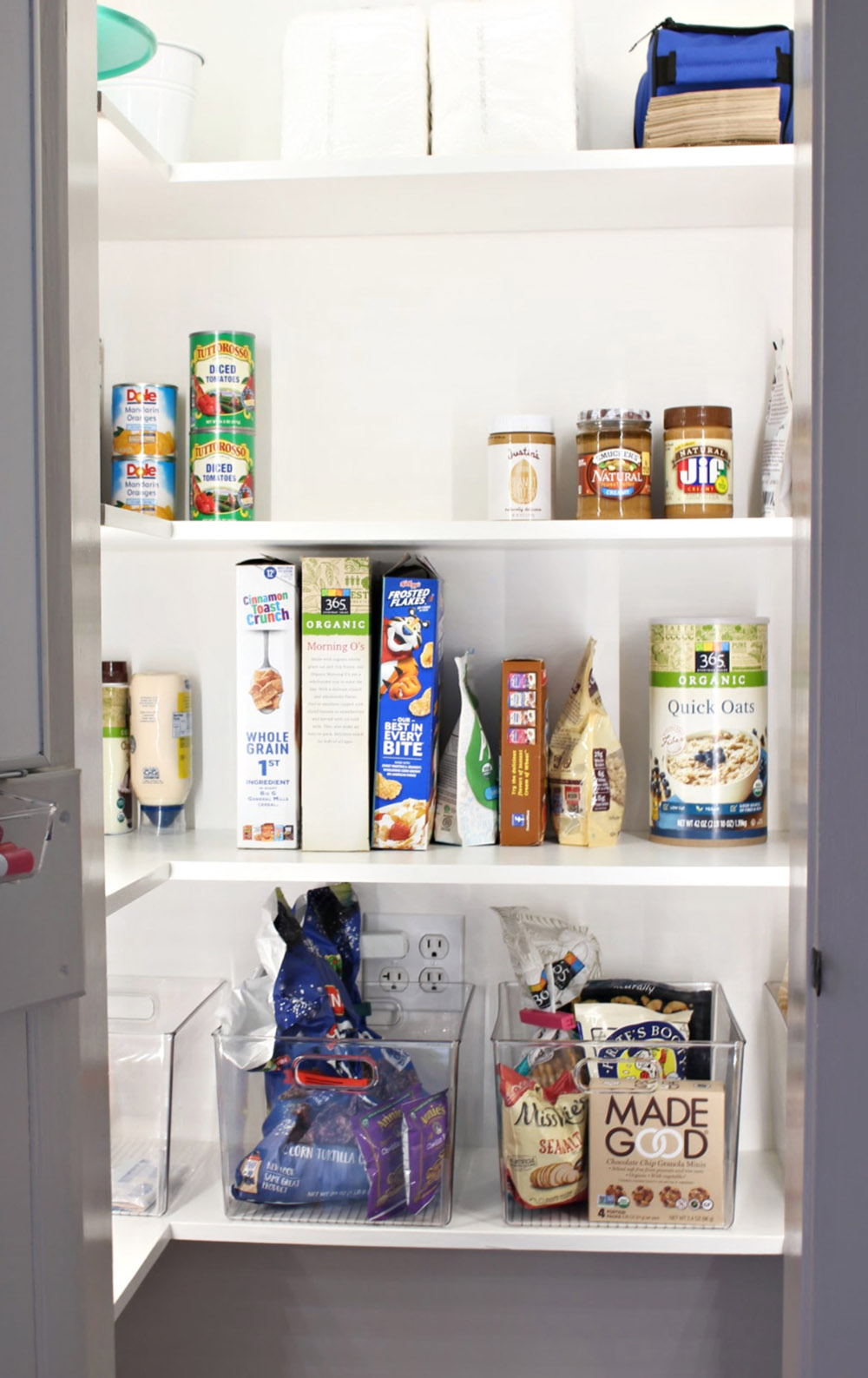 A pantry organized with clear storage bins.