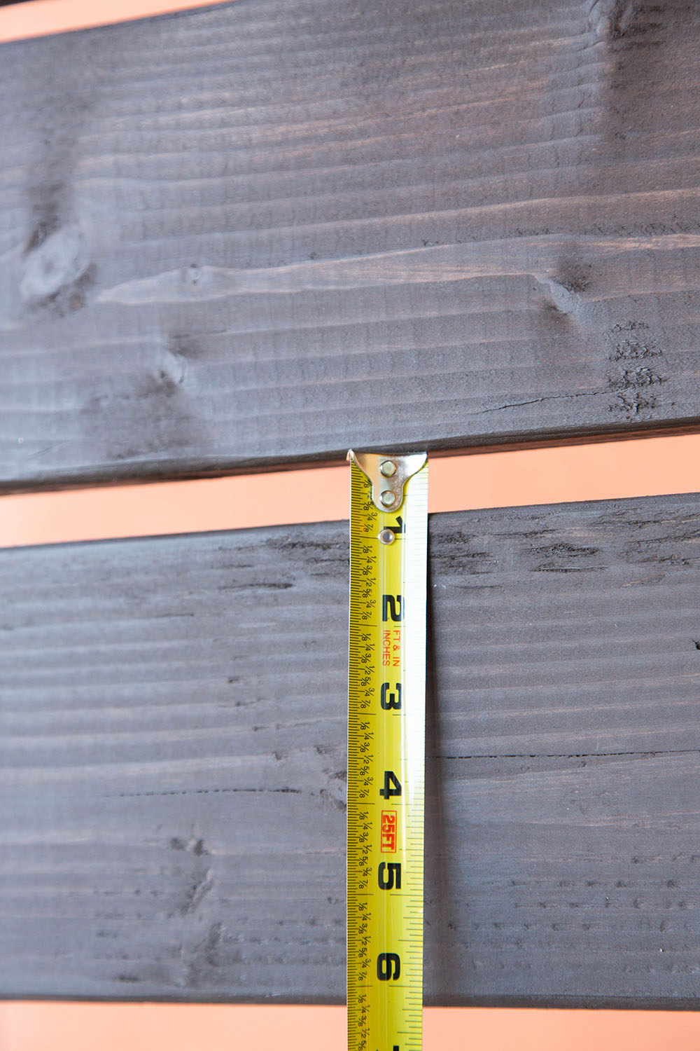 A measuring tape against two pieces of wood.