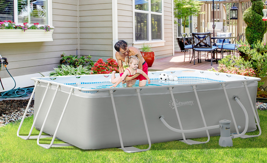 A dad and child in an above-ground pool.