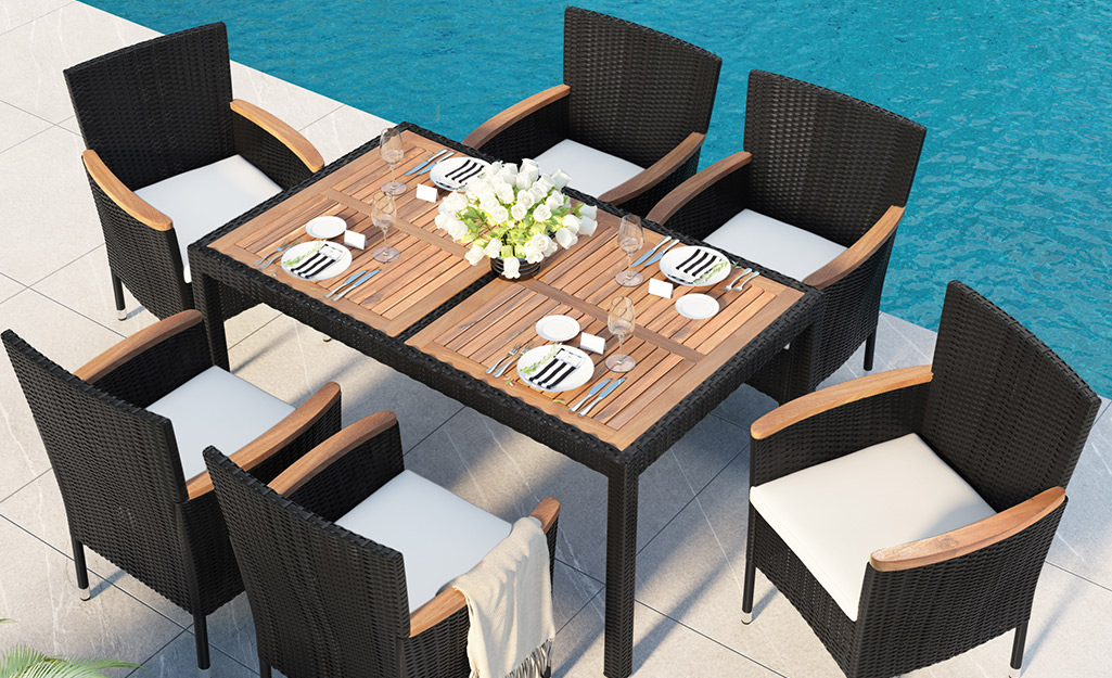 An outdoor dining set next to a pool.