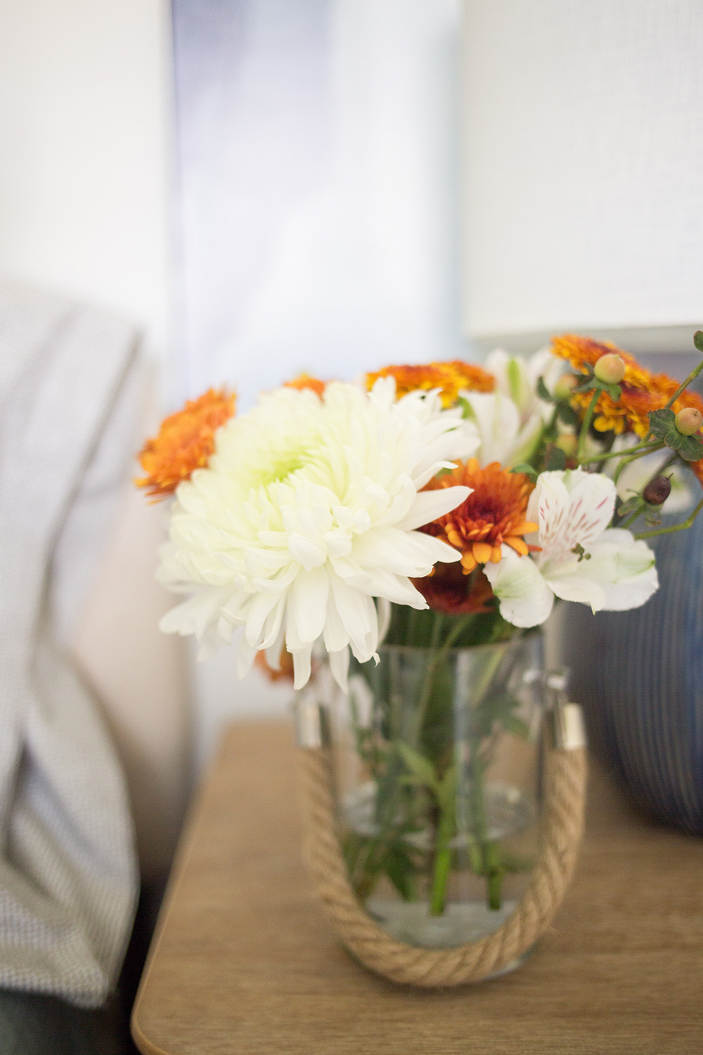 A vase full of fresh flowers sitting on a nightstand.