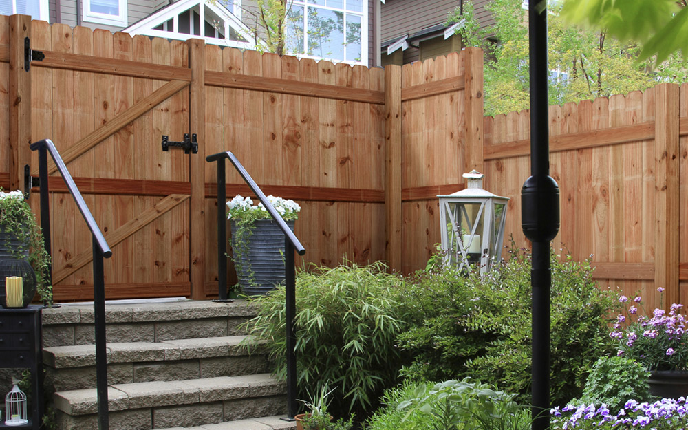 Wooden stockade-style privacy fencing with rounded tops.