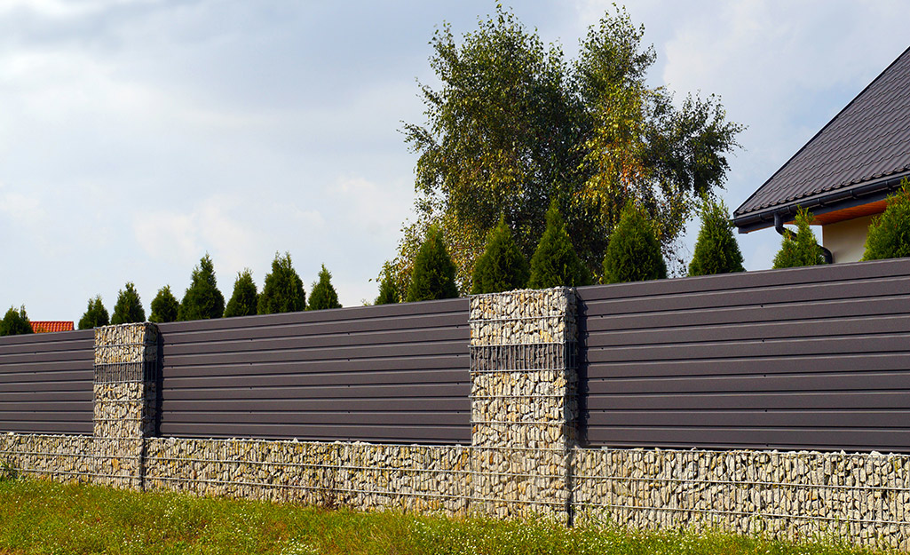 Horizontal slats and stonework give this privacy fence a modern look