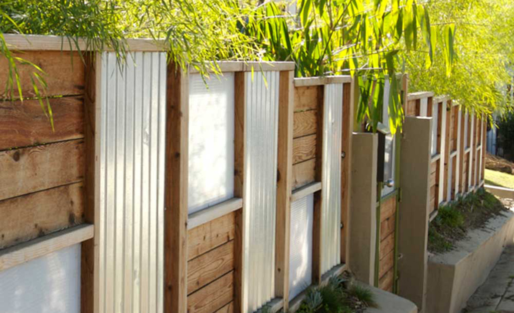 Alternating panels of wood and corrugated metal add interest to this fence