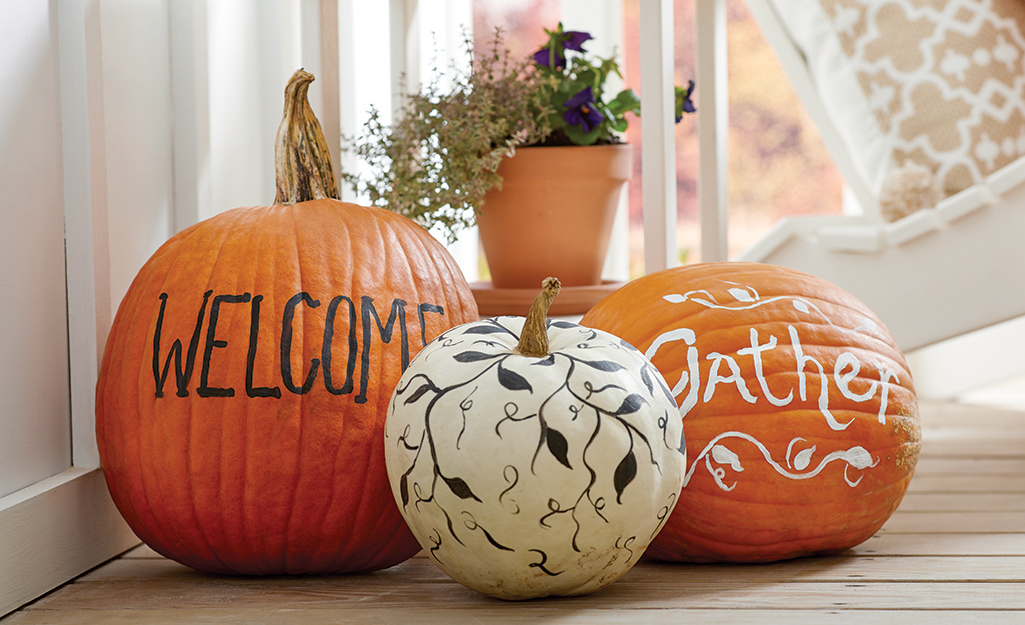 Pumpkins painted and decorated with sayings and vines.