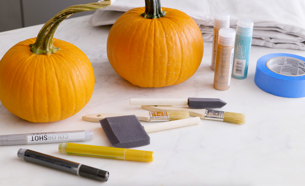 Two pumpkins and various painting supplies. 