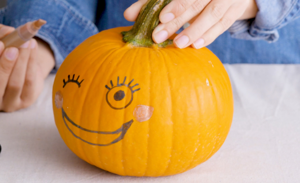 A pumpkin painted with a smiling face.