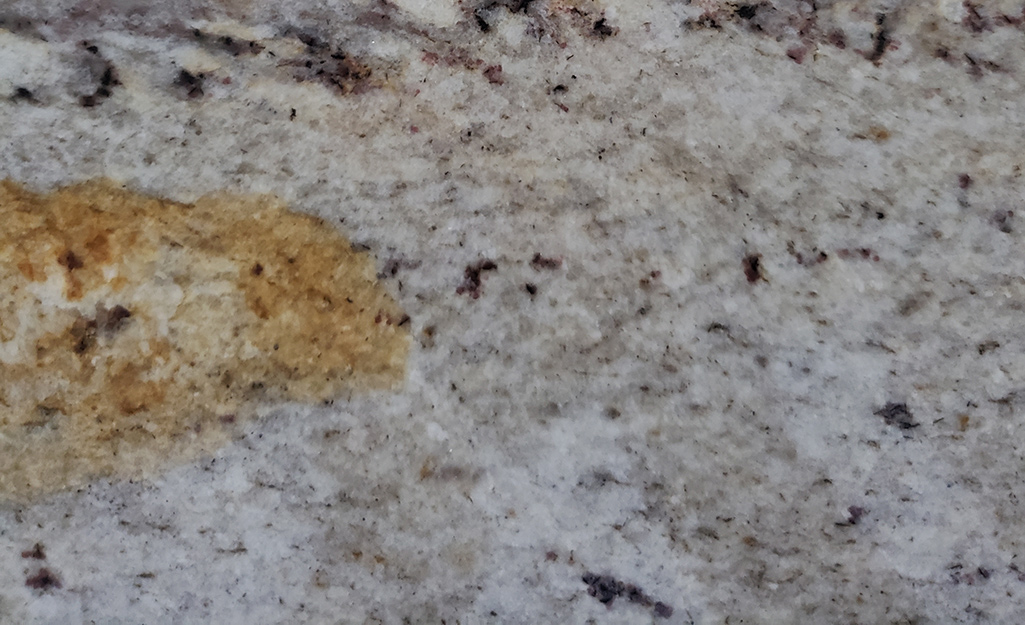 Light granite countertop featuring a dark stain.