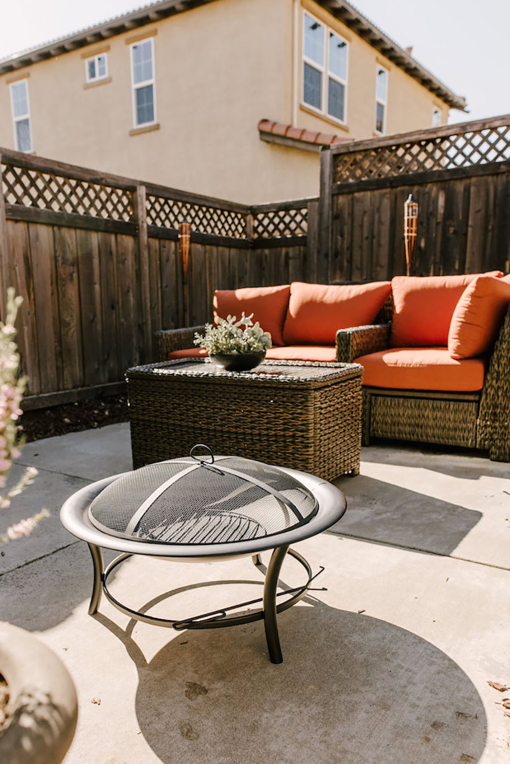 An updated patio with a fire pit, plants, and outdoor seating.