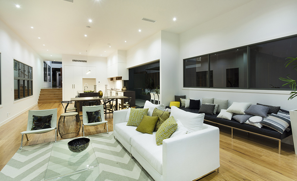 An open concept living room with three rows of ceiling recessed lighting.