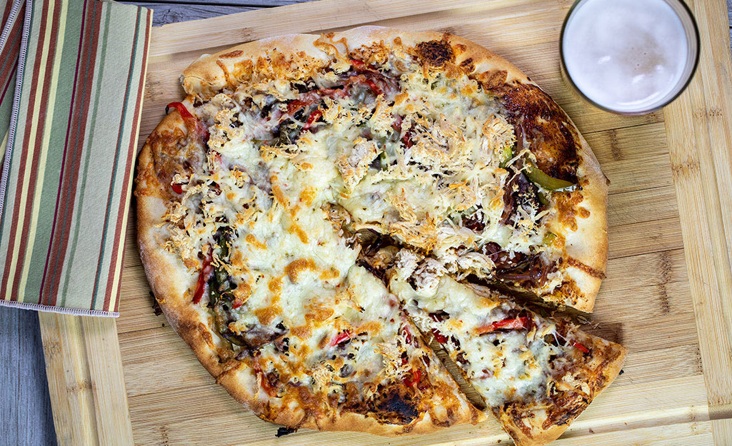Pizza with grilled peppers on a cutting board Pizza with grilled peppers on a cutting board