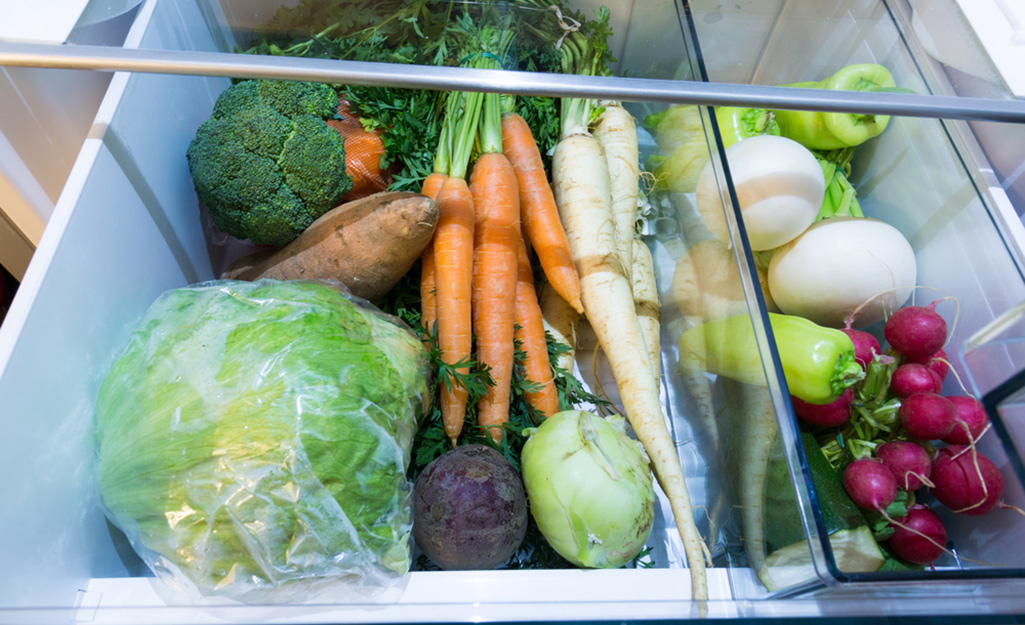 A compartment of a refrigerator filled with vegetables. 