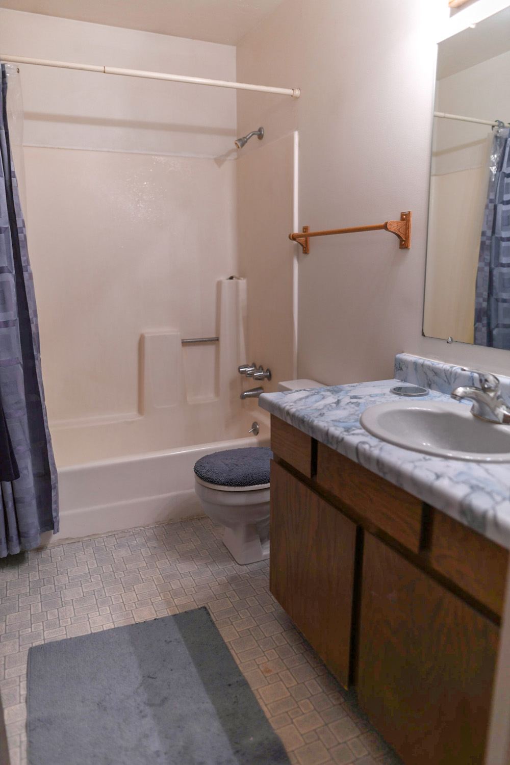 An outdated 36-year-old bathroom with a brown vanity. An outdated 36-year-old bathroom with a brown vanity.