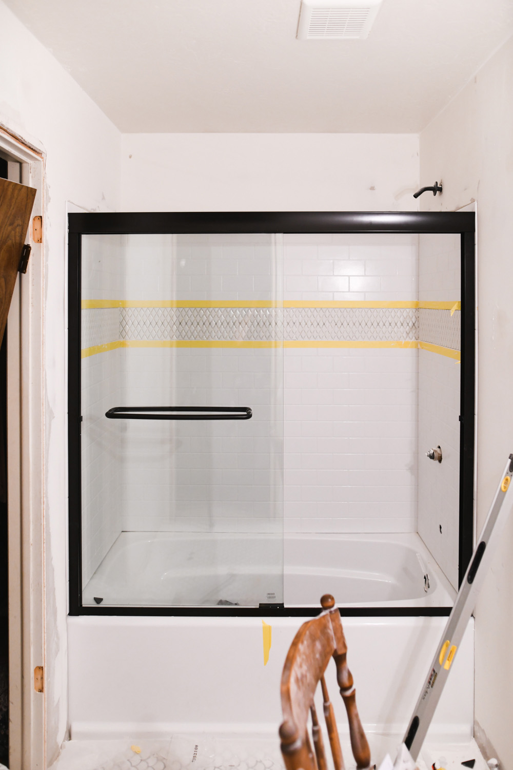 A shower with a Delta UPstile shower surround and glass doors.